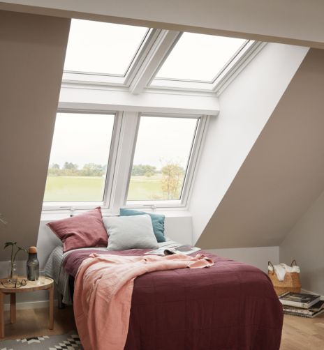 Camera da letto luminosa con quattro grandi finestre per tetti VELUX.