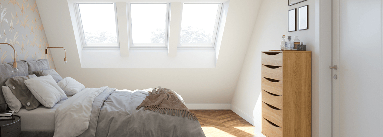 Tre finestre per tetti VELUX illuminano un'elegante camera da letto nell'attico