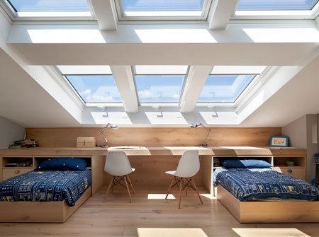 Una camera dei bambini piccola e luminosa con una finestra per tetti VELUX e un abbaino.