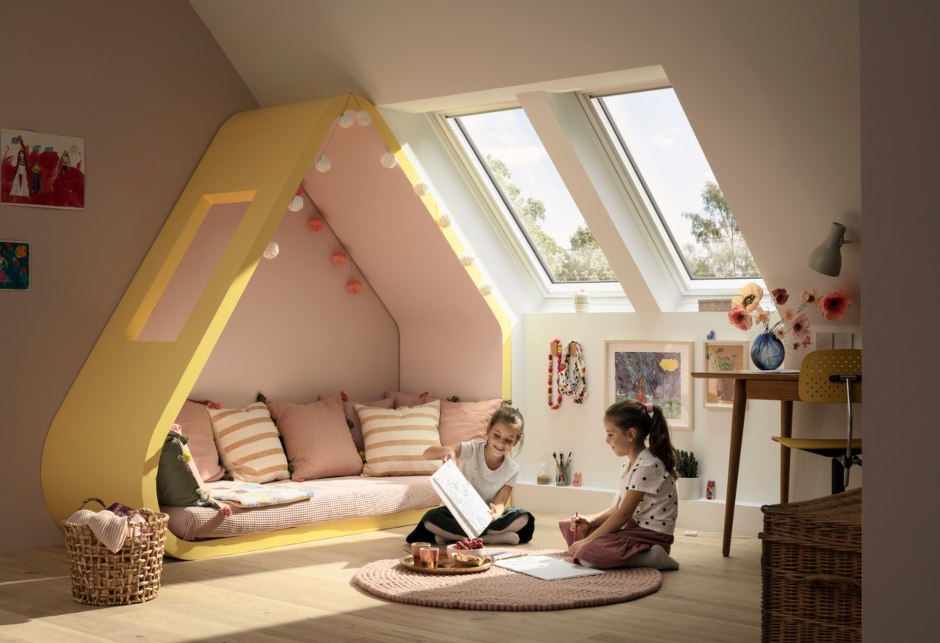 Zwei Kinder in einem hellen Kinderzimmer spielend, mit zwei VELUX Dachfenstern.